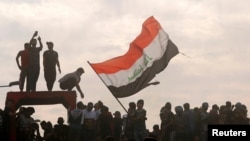 Iraqi demonstrators gather to mark the first anniversary of the anti-government protests in Baghdad, Iraq, Oct. 25, 2020. 