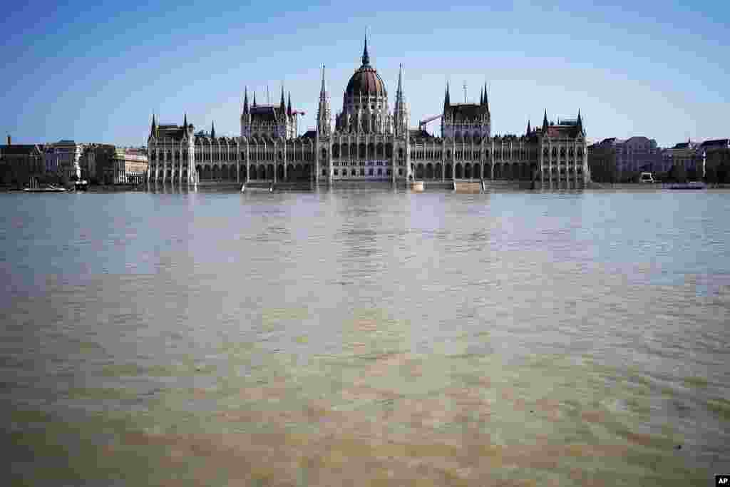 Gedung Parlemen dengan arsitektur indah terlihat terancam banjir saat permukaan Sungai Danube naik membanjiri tepiannya di pusat ibu kota Budapest, Hungaria. (AP)&nbsp;