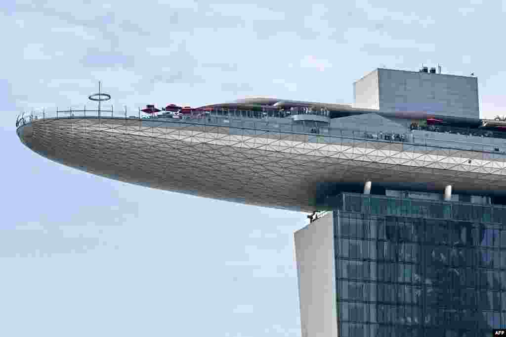 Visitors stand on the roof deck of the Marina Bay Sands Skypark in Singapore.