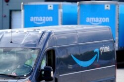 FILE - An Amazon Prime logo appears on the side of a delivery van as it departs an Amazon Warehouse location, Oct. 1, 2020, in Dedham, Mass.