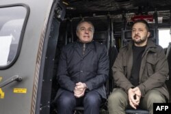 FILE - Switzerland's Foreign Minister Ignazio Cassis (L) and Ukrainian president Volodymyr Zelensky (R) get ready for takeoff in a Swiss Air Force helicopter following Zelensky's arrival at Zurich airport in Kloten, on January 15, 2024.
