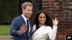 FILE - Britain's Prince Harry and his then-fiancee Meghan Markle pose for photographers on the grounds of Kensington Palace in London on Nov. 27, 2017.