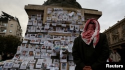 A man looks at the pictures of missing people, believed to be prisoners from Sednaya prison, which was known as a "slaughterhouse" under Syria's Bashar al-Assad's rule, after his ousting, in Marjeh Square in Damascus, Dec. 22, 2024.