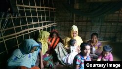 Samsun Nahar, a Rohingya widow, and her 9 children in their bamboo-and-plastic shack in a refugee colony in Kutupalong, Cox’s Bazar, Bangladesh. Nahar is looking for grooms for her 13 and 14-year old daughters. (Photo by Noor Hossain)