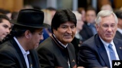 El presidente de Bolivia, Evo Morales, (centro), sonríe en la Corte Internacional de Justicia de la ONU donde los jueces fallaron sobre una solicitud de Bolivia para que se ordene a Chile iniciar conversaciones con su vecino sobre un acceso al mar a través de su territorio. La Haya, Holanda, 1 de octubre de 2018.