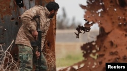 A member of the Libyan pro-government forces is seen during a clash with the Shura Council of Libyan Revolutionaries, an alliance of former anti-Gadhafi rebels who have joined forces with the Islamist Ansar al-Sharia, in Benghazi, March 16, 2015.