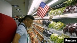 FILE - A man stands at a fruit section of a supermarket in Hanoi, Vietnam, Sept. 20, 2014. 