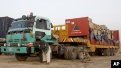 A driver washes his face near a truck carrying NATO supplies at the Pakistani-Afghan border in Chaman, Pakistan, July 5, 2012. 