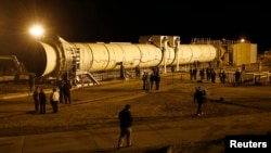 Members of the media gather around the five-segment solid rocket motor before it undergoes a static test fire at the Orbital ATK facility in Promontory, Utah, March 11, 2015.