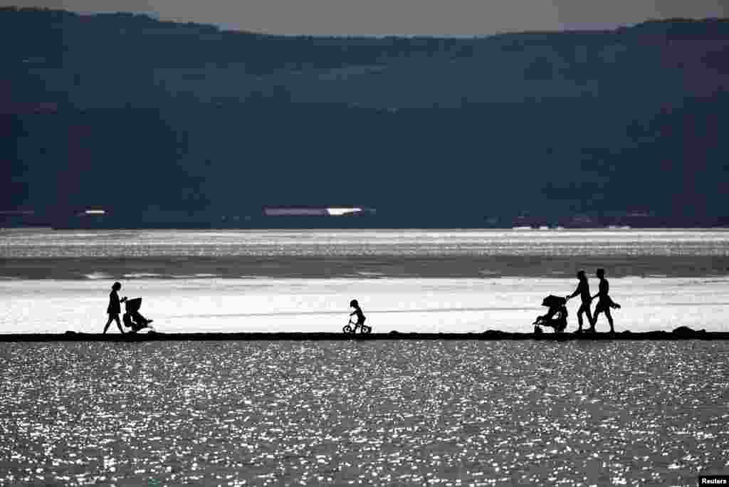 People walk along the Marine Lake at West Kirby, Britain.