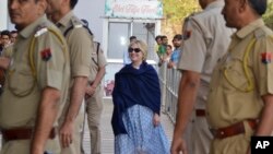 In this Thursday, March 15, 2018 photo, former U.S. Secretary of State Hillary Clinton, center, arrives at the departure terminal of Jodhpur airport in Rajasthan state, India.