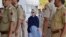 In this Thursday, March 15, 2018 photo, former U.S. Secretary of State Hillary Clinton, center, arrives at the departure terminal of Jodhpur airport in Rajasthan state, India.