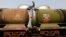 FILE - A worker walks atop a tanker wagon to check the freight level at an oil terminal on the outskirts of Kolkata, Nov. 27, 2013. 