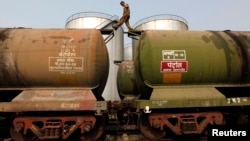 Seorang pekerja berjalan di atas gerobak tanker di terminal minyak di pinggiran Kolkata, 27 November 2013. (Foto: dok).