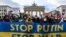 Demonstrators display a banner in the colors of the Ukrainian flag during a protest at Berlin's Brandenburg Gate on January 30, 2022. (John MACDOUGALL / AFP) 