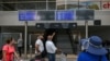 Passengers look at schedule flights screen at Rafic Hariri International Airport after their flights were delayed or cancelled in Beirut on July 29, 2024.