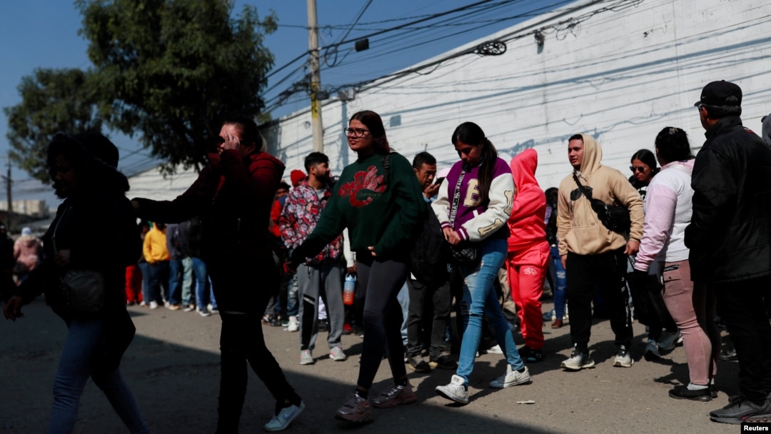 Migrantes, en su mayoría de Haití, Cuba y Venezuela, se reúnen afuera de la Comisión Mexicana de Ayuda a Refugiados (COMAR), mientras esperan en fila para regularizar su situación migratoria en el país, en la Ciudad de México, México, el 24 de enero de 2025.