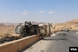 Debris, burnt-out cars and bullet casings remain a day after the battle on the road out of Gharyan, Tripoli. (H.Murdock/VOA)