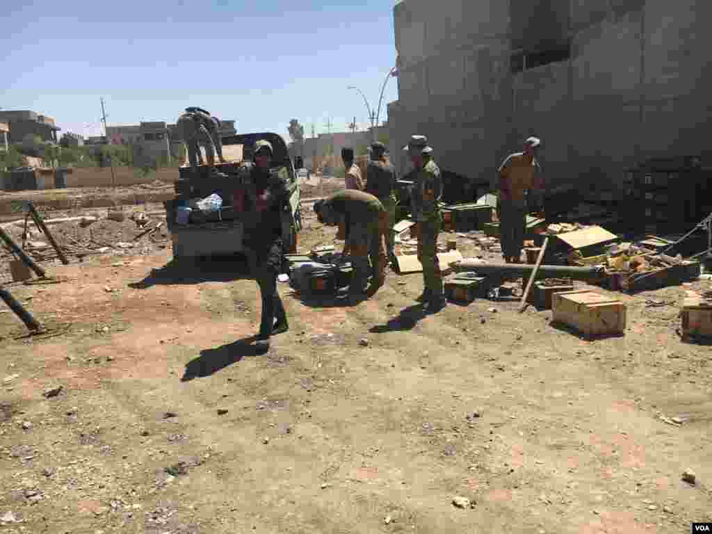 First to the right, an Iraqi solider carries a rocket on his shoulder as other members of Iraqi Rapid Response unit in 17th Tamouz neighborhood prepare for an attack on Islamic State militants across the street in al-Zanjili neighborhood in Mosul, Iraq, May 31, 2017. (K.Omar/VOA) &nbsp;