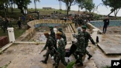 Para anggota TNI membawa jenazah korban tewas pasca tsunami di kawasan wisata Tanjung Lesung, Pandeglang. 