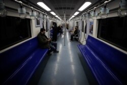 Commuters ride in a quiet subway train during the morning rush hour in Beijing, Feb. 17, 2020.