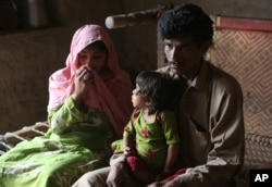 Pakistan's Tariq Ali, 30 along with his wife Parveen and 3-year-old Ume Kulssom all infected with HIV sit at their home near Ratodero, May,16, 2019.