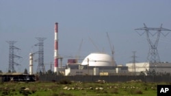 FILE - The reactor building of an Iranian nuclear power plant and electricity poles are seen at Bushehr, Iran, Feb. 27, 2005. Iranian power officials said organized blackouts would begin on Dec. 14, 2024.