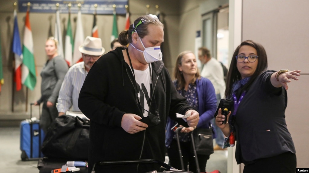 FILE PHOTO: A ticket agent helps travelers arriving on a flight from Frankfurt, Germany 