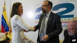 María Corina Machado, ganadora de la primaria presidencial opositora, saluda al presidente de la comisión organizadora del proceso, Jesús María Casal, este jueves 26 de octubre de 2023, en un acto realizado en Caracas.