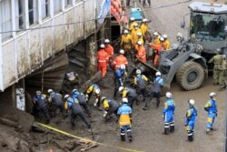 Rescuers conduct a rescue and search operation at a mudslide site at Izusan district in Atami, west of Tokyo, Japan, July 6, 2021. (Kyodo/via Reuters)