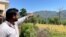 A young Kashmiri pointing toward the Indian army posts on the hilltops lining the de facto Kashmir frontier with Pakistani-administered part of the divided region. (Ayaz Gul/VOA)
