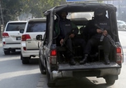 Police officers escort vehicles transporting Hafiz Saeed, founder of the Pakistani religious group Jamaat-ud-Dawa, following his court appearance, in Lahore, Pakistan, Feb. 12, 2020.