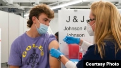 Bradley Sharp asal Saratoga New York menerima vaksin COVID-19 Johnson & Johnson dari perawat, Stephanie Wagner di New York. Bradley perlu divaksinasi COVID-19 karena diwajibkan oleh kampusnya (dok: AP Photo/Mark Lennihan)