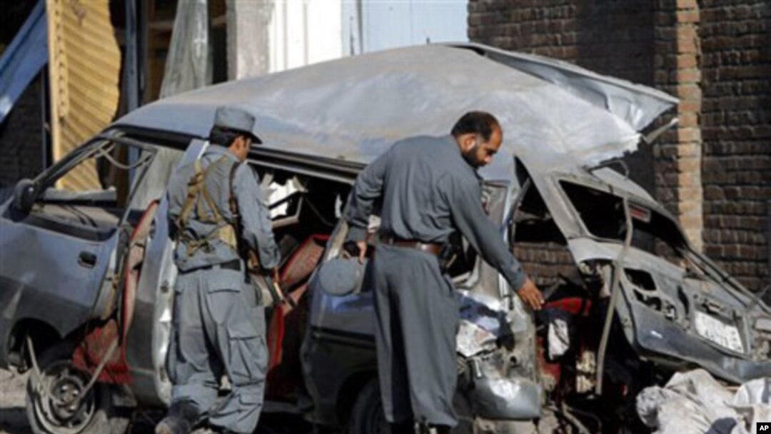 Dua polisi Afghanistan memeriksa lokasi ledakan bom mobil (foto: dok). Seorang pria berseragam polisi Afghanistan menembak tewas tiga tentara Inggris, Minggu (1/7). 