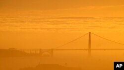 A blanket of fog is seen behind the Golden Gate Bridge and Alcatraz Island as the sun sets Sunday, Feb. 28, 2016, in Berkely, Calif. The San Francisco Bay area is one of the most expensive areas to live in the world. 