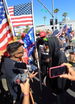 A protester supporting the Black Lives Matter movement confronts a supporter of President Donald Trump, August 29, 2020, Los Angeles, California.