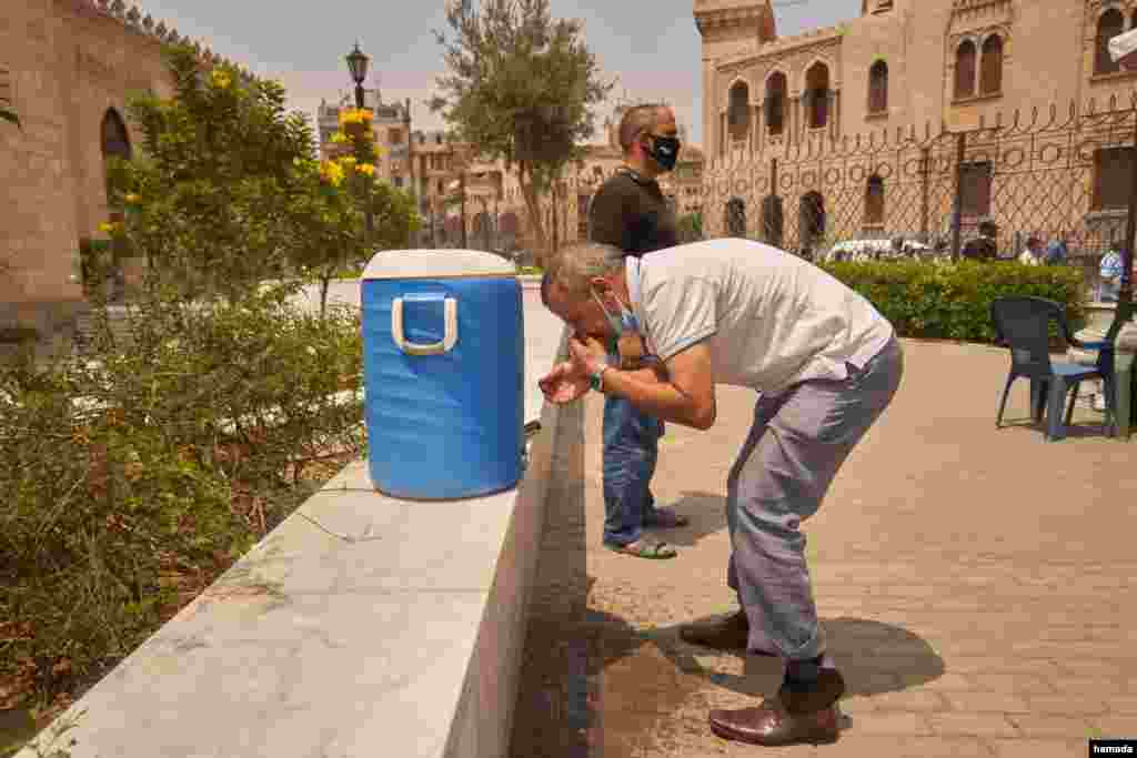 Bathrooms and washing rooms are closed at the mosque because of the pandemic, so worshippers improvise their traditional pre-prayer cleaning, Aug. 28, 2020 in Cairo. (Hamada Elrasam/VOA)
