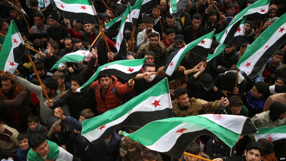 Syrians attend a gathering to mark 13 years since pro-democracy protests swept the country in the rebel-held city of Idlib, in northwestern Syria, on March 15, 2024.