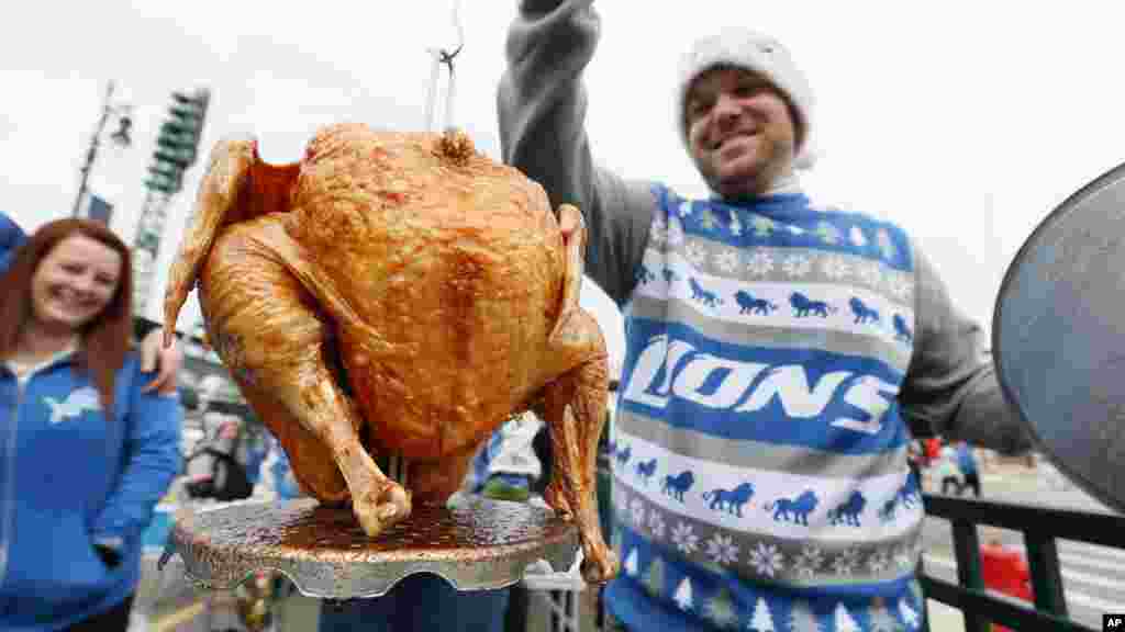 Brent Clodgio checks a Thanksgiving turkey while tailgating before an NFL football game between the Detroit Lions and Chicago Bears in Detroit, Nov. 27, 2014.