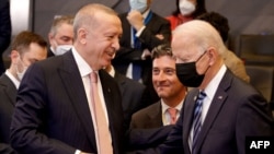 Presiden Turki Recep Tayyip Erdogan dan Presiden AS Joe Biden berbincang-bincang sebelum sidang paripurna NATO di markas NATO, di Brussels, Senin, 14 Juni 2021. (Foto: Olivier Matthys/Pool/AFP)