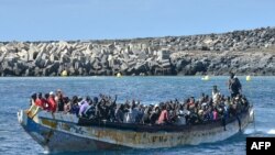 TOPSHOT - Para migran tiba dengan perahu di dermaga La Restinga, El Pinar di Pulau Canary El Hierro, Spanyol, 21 Oktober 2023. (STRINGER / AFP)