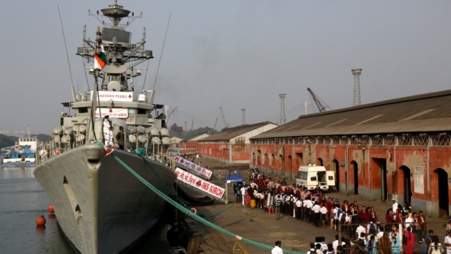 File - Indian school children walk past the visiting Indian Navy warship INS Kirch for a guided tour in Kolkata, Dec. 5, 2019. India is sending four navy ships for exercises and port visits in the Indo-Pacific region as China's maritime power grows.