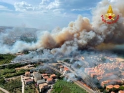 In this photo released by the Italian Firefighters, a view of a violent wildfire that burned the historical pinewood in Pescara, central Italy, Aug. 1, 2021.