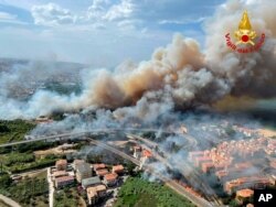 In this photo released by the Italian Firefighters, a view of a violent wildfire that burned the historical pinewood in Pescara, central Italy, Aug. 1, 2021.