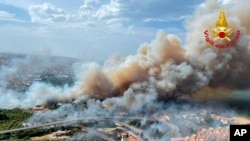 In this photo released by the Italian Firefighters, a view of a violent wildfire that burned the historical pinewood in Pescara, central Italy, Aug. 1, 2021.