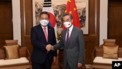 South Korean Foreign Minister Park Jin, left, meets with his Chinese then-counterpart Wang Yi in Qingdao, China, on Aug. 9, 2022. Talks among the foreign ministers of China, South Korea and Japan are expected to take place as soon as this weekend. (Xinhua News Agency via AP)