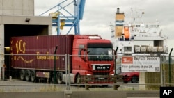 Spanduk bertuliskan 'Brexit proof' dipasang di pagar pengaman saat sebuah truk melewati terowongan pemindaian di Pelabuhan Zeebrugge, di Zeebrugge, Belgia, Kamis, 24 Oktober 2019. (Foto: AP)