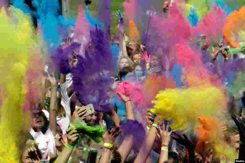 People throw colors in the air during a Holi color festival in Riga, Latvia.