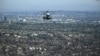 The Marine One helicopter, carrying U.S. President Donald Trump, flies above devastation caused by wildfires, near Los Angeles, California, Jan. 24, 2025. (Photo by Mandel Ngan/Pool/AFP)