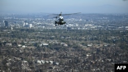 The Marine One helicopter, carrying U.S. President Donald Trump, flies above devastation caused by wildfires, near Los Angeles, California, Jan. 24, 2025. (Photo by Mandel Ngan/Pool/AFP)